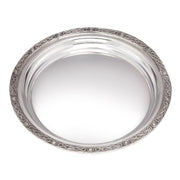 Silver decorative plate with intricate patterns on a white background