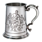Silver tankard with engraved design of three men playing a game, on a white background