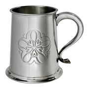 Silver tankard with floral embossing on a white background