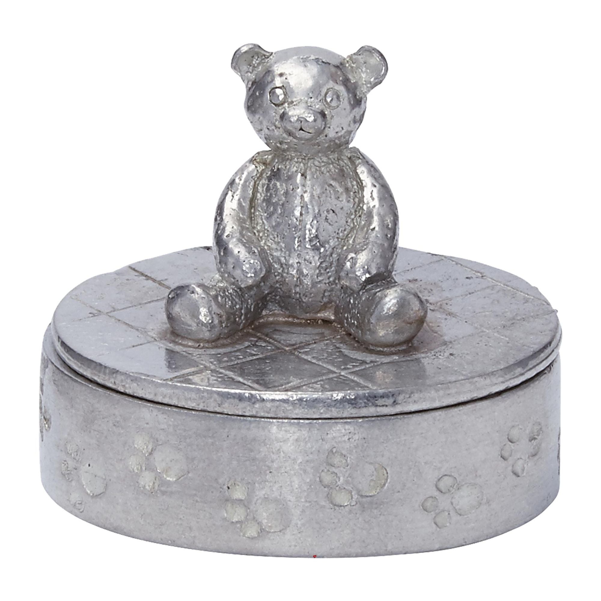 Silver teddy bear on top of a round silver box with paw print design on a white background