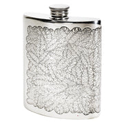 Silver hip flask with leaf pattern on a white background