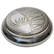 Silver decorative object with floral design on a white background