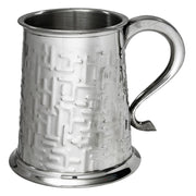 Silver tankard with textured surface and handle on a white background