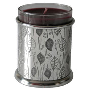Candle in a decorative container with leaf pattern on a white background