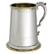 Silver tankard with brass interior and base on a white background