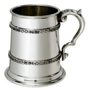 Silver tankard with decorative handle on a white background