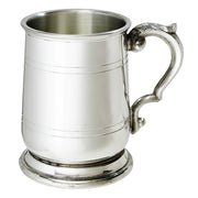 Silver tankard with a decorative handle on a white background