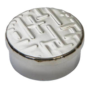 Round ceramic object with embossed design on a white background