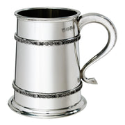 Silver tankard with Celtic knot designs on a white background
