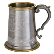 Decorative metal mug with engraved design on a white background