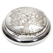 Silver decorative object with tree of life design on a white background